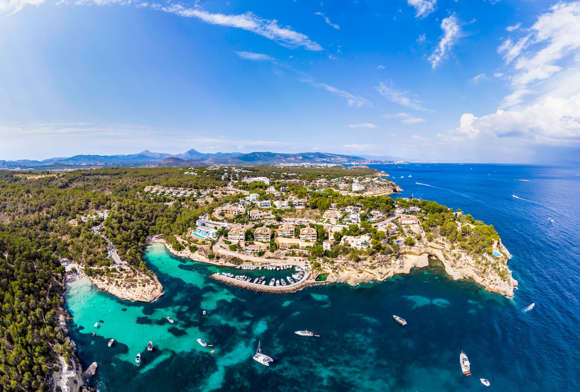 Superyacht at anchor along a rocky coastline