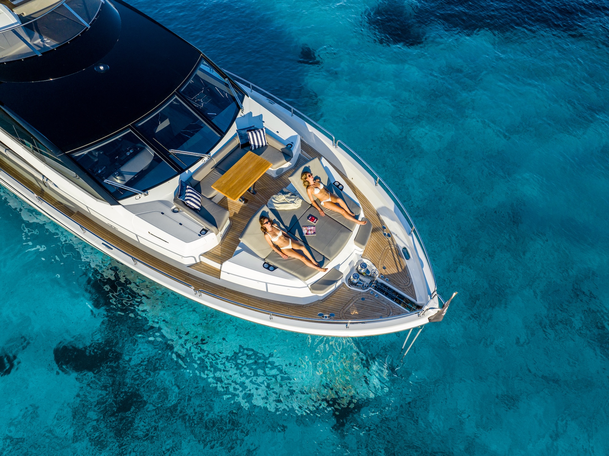 Guests relaxing on a yacht aft deck at sunset